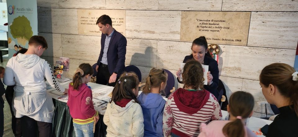 Egy ember képet mutar a gyerekeknek