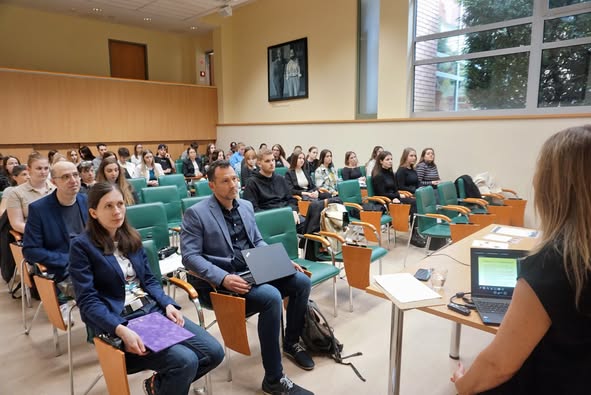 Emberek figyelnek a prezentációra.